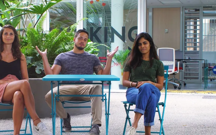 Trois invités assis face caméra dans un patio végétalisé, autour d'une table bleue