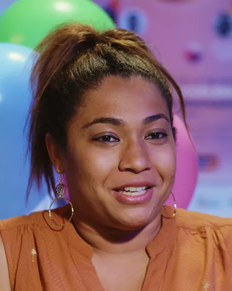 Gros plan d'une femme souriante devant des ballons de fête colorés